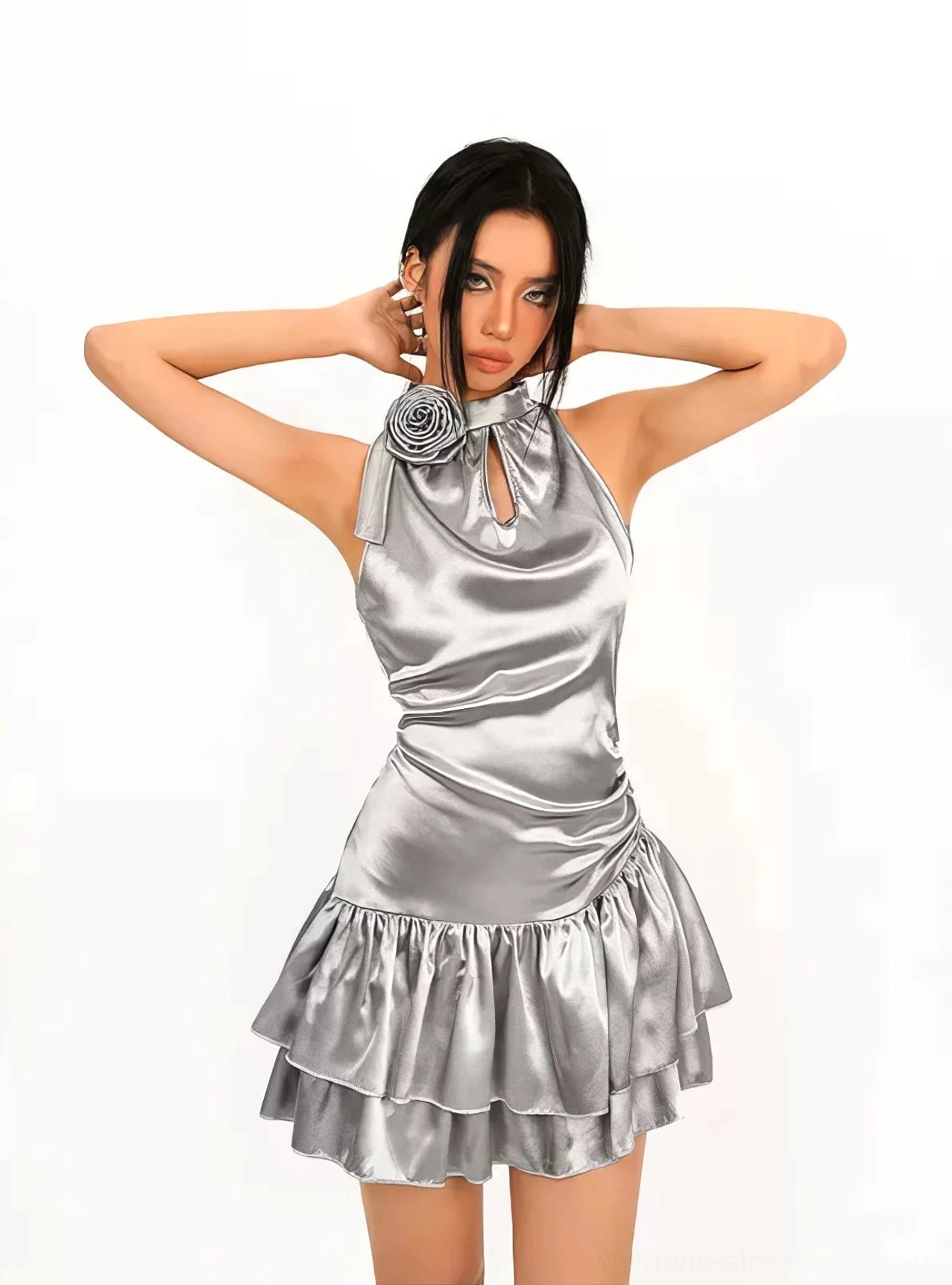 Front view of a silver metallic halter cocktail mini dress with 3D flower neckline, front keyhole cutout, fitted bodice, glossy satin-look finish, and double ruffled hem