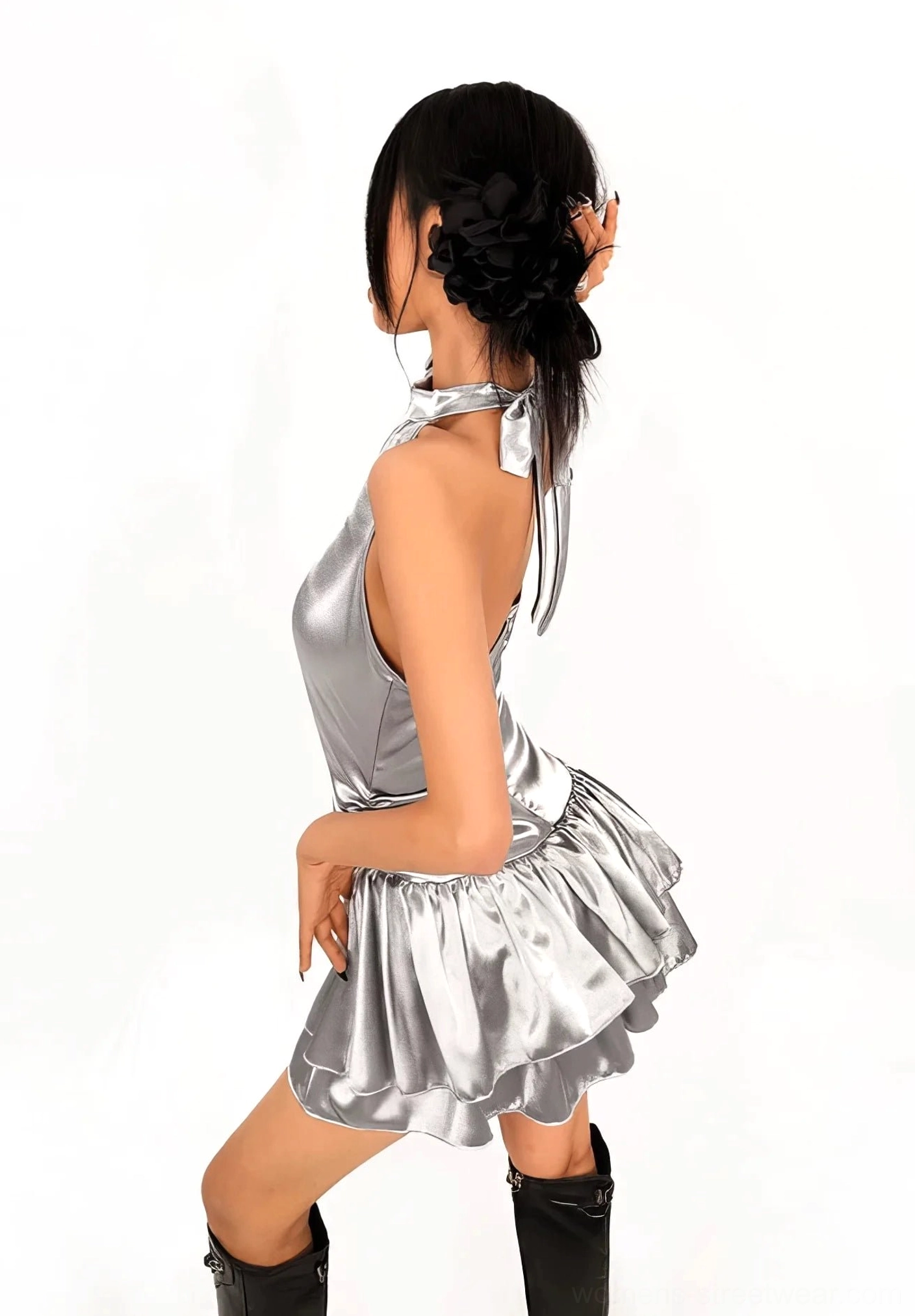 Back side view of a silver metallic halter mini dress showing the adjustable neck tie, fitted waist, open back, and double ruffled skirt hem
