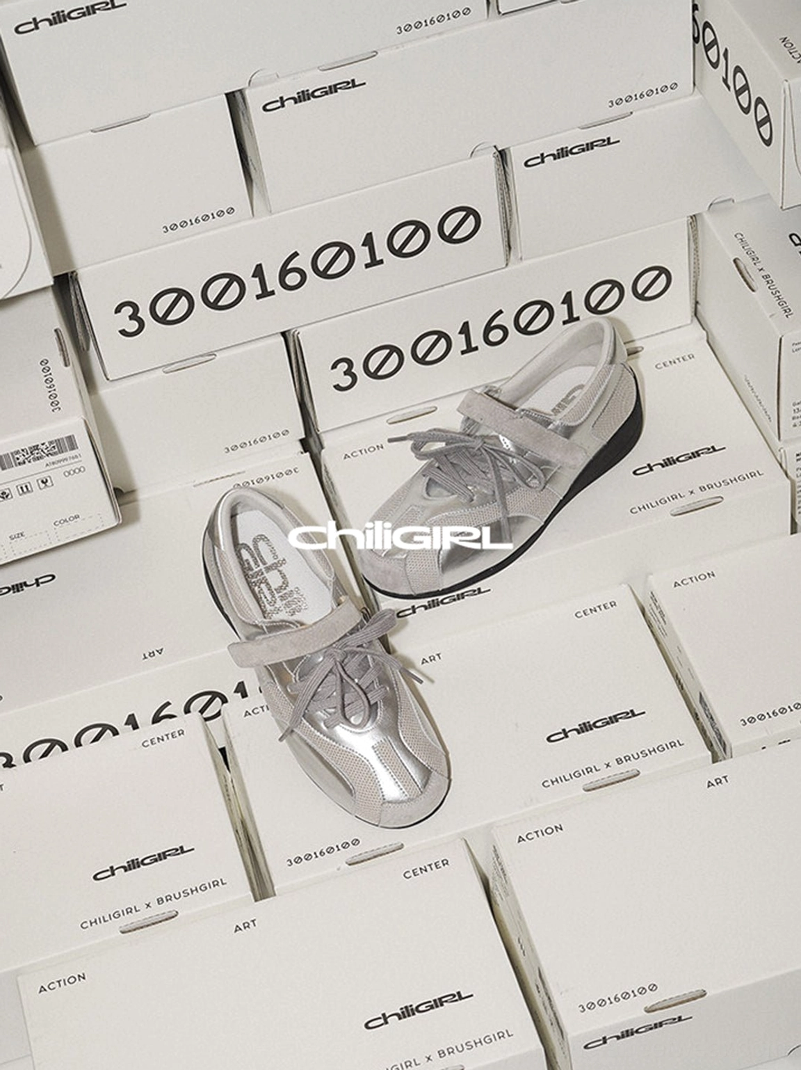 Silver metallic mesh streetwear trainers shown with sneaker boxes, featuring adjustable Velcro straps and low-top design