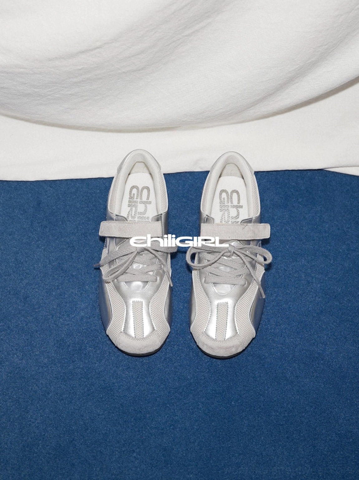 Pair of silver metallic mesh Velcro trainers shown from a top front angle with breathable panels and low-top streetwear silhouette