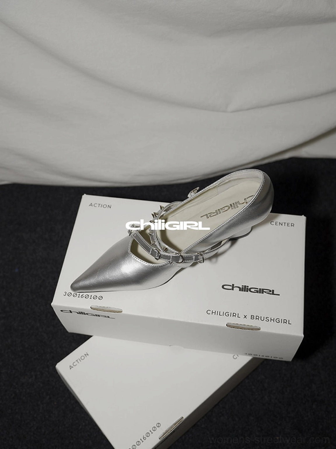 Metallic silver pointed toe pumps with double buckle straps and a sculpted low wedge heel in three quarter view