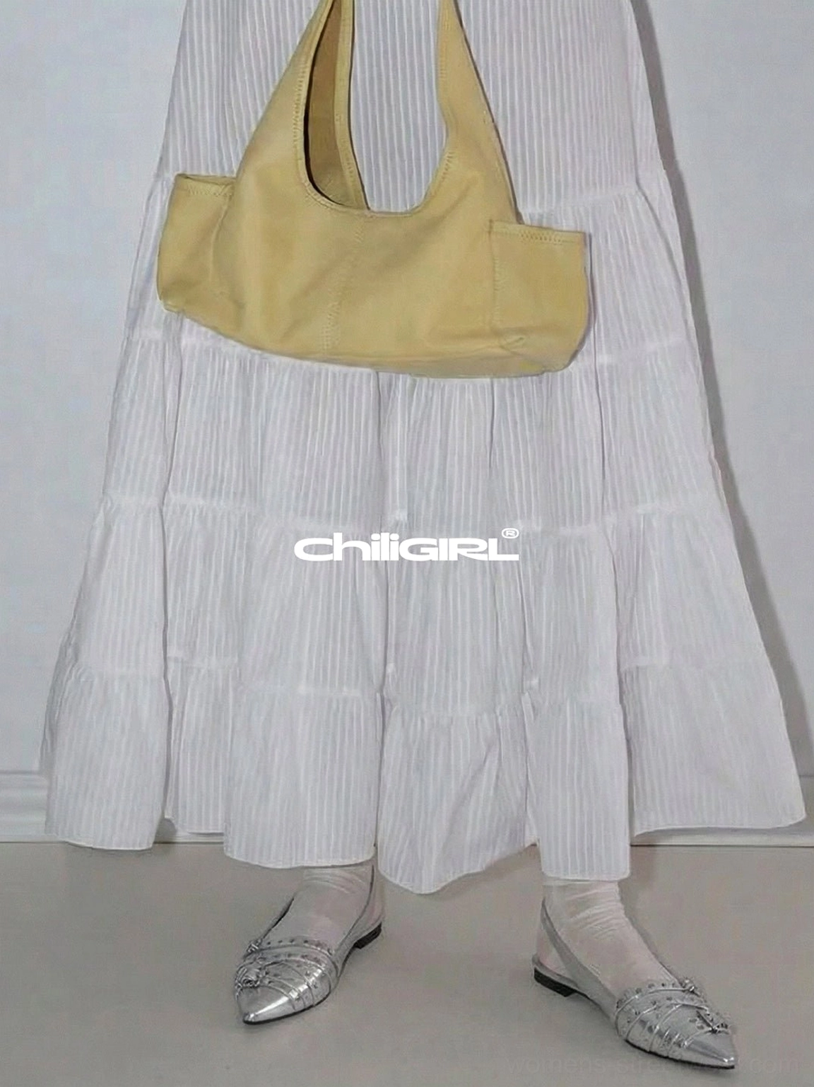 Silver metallic slingback flats styled with sheer socks, a white pleated maxi skirt, and a yellow mini shoulder bag