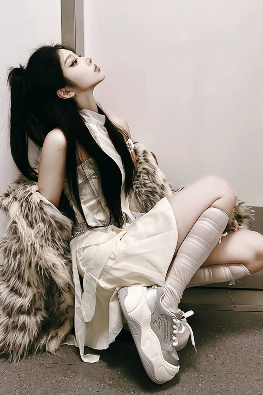 Silver and white chunky platform sneakers worn with cream dress stockings and oversized fur coat