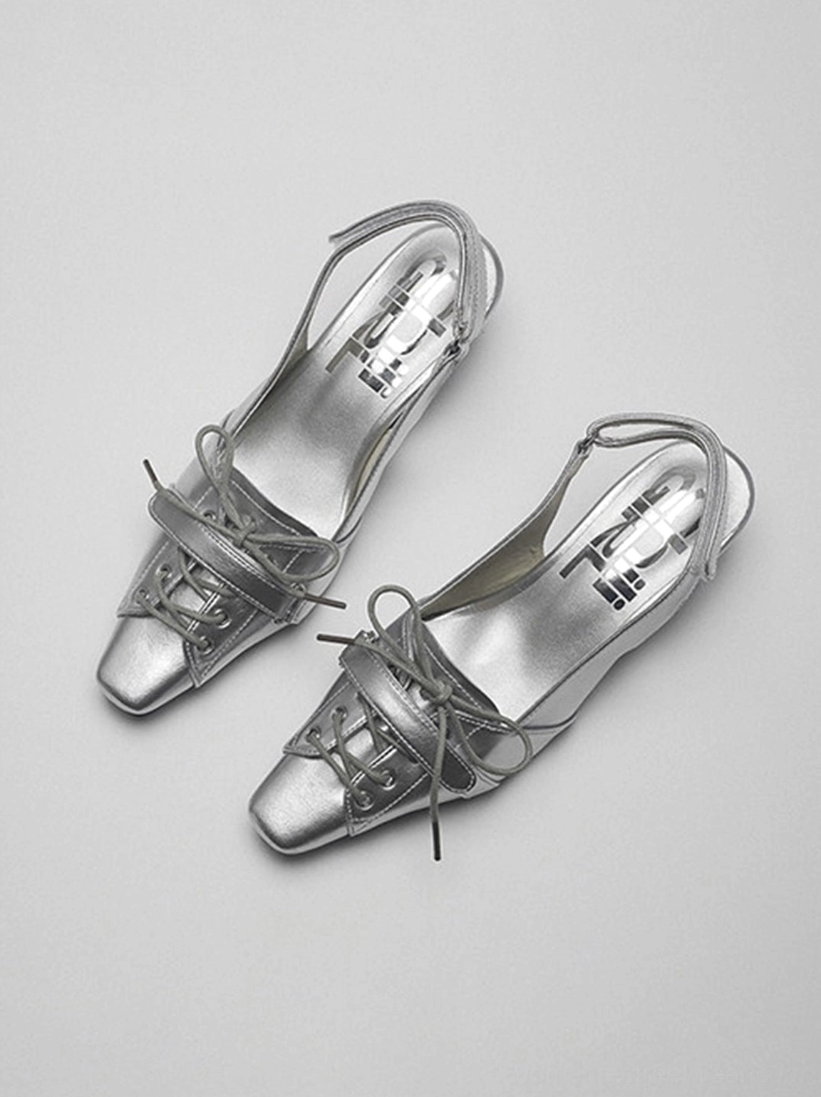 Silver pointed-toe kitten heel slingback shoes with bow detail and delicate straps, product showcase image