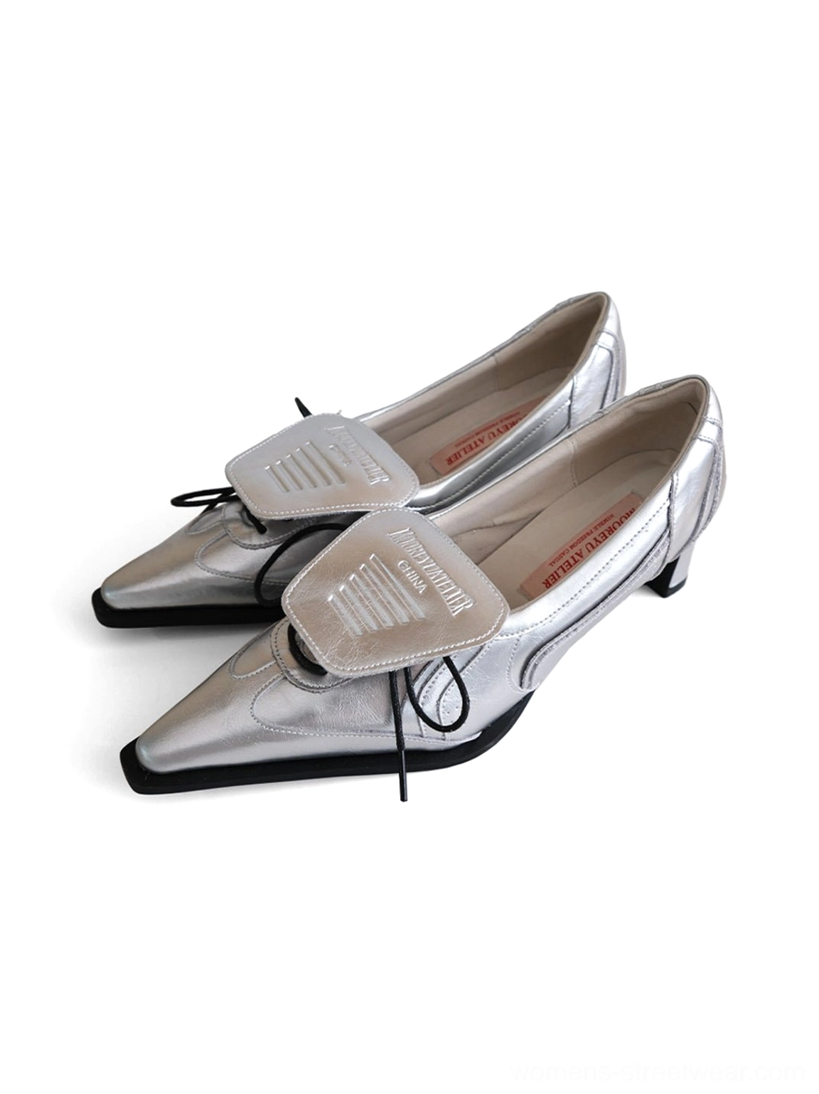 Silver pointed-toe pumps with drawstring lace flap and sculpted toe displayed on a white background