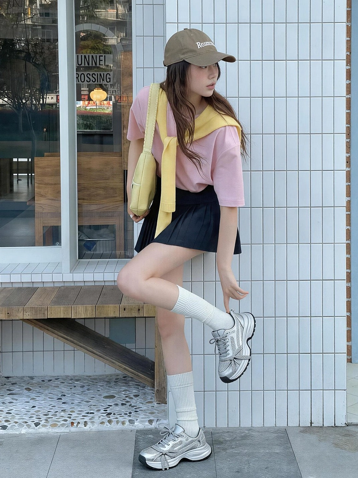 Side view of silver rhinestone chunky dad sneakers styled with a pink top and pleated black skirt for Korean-inspired fashion