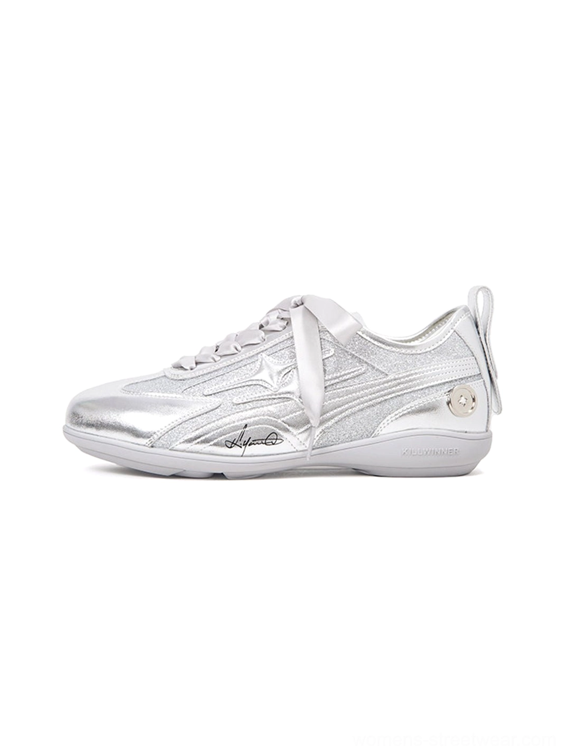 Side profile of silver sculpted-panel women's athletic trainers with metallic upper, ribbon laces, low runner sole, and futuristic streetwear design