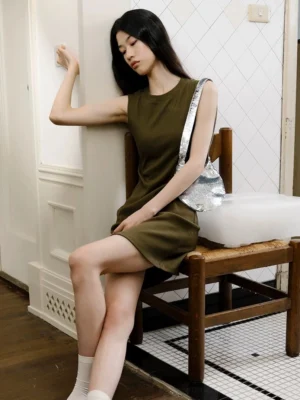 Model wearing a silver sequin crescent shoulder bag with an olive green mini dress for a Y2K party look