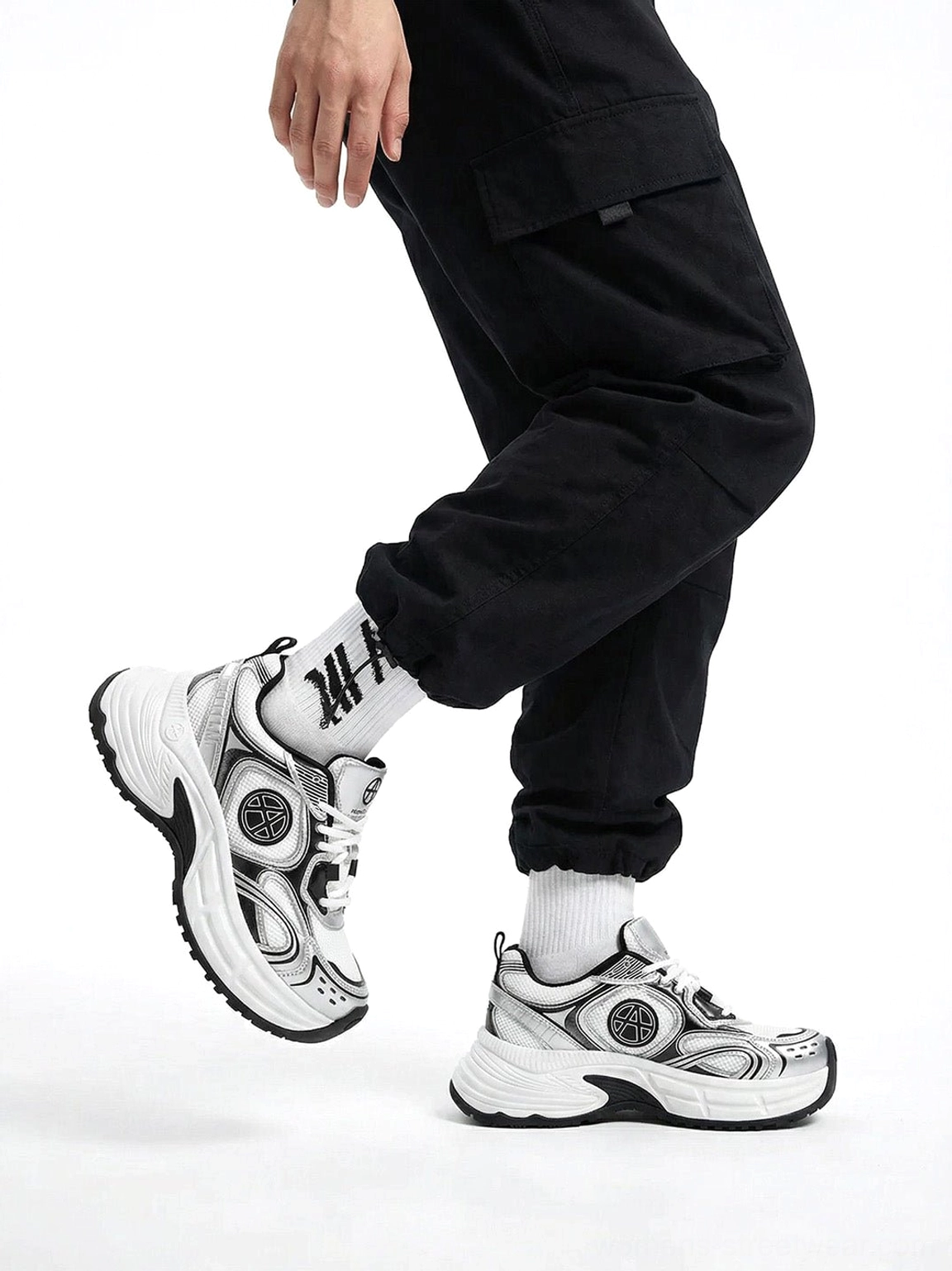 Silver Wave chunky dad sneakers worn with black cargo pants and graphic socks showing the circular side logo and streamlined upper
