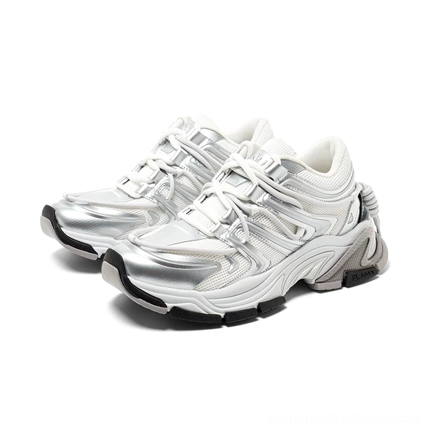 Silver white chunky runner sneakers shown in three-quarter side view with layered metallic sculpted panels, thick rubber sole, lace-up front, padded low-top collar, and heel drawstring detail
