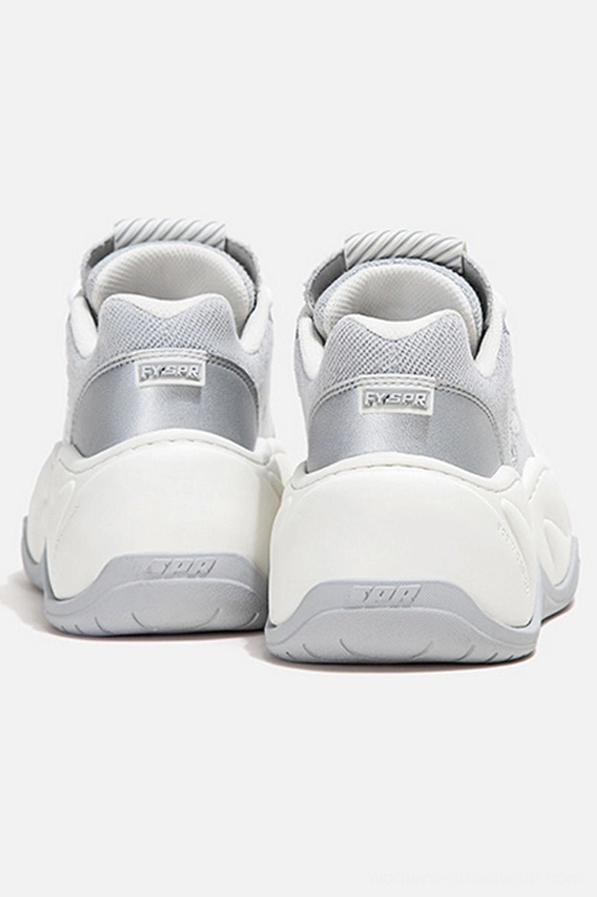 Rear view of silver and white chunky platform sneakers showing layered wave outsole and heel tabs