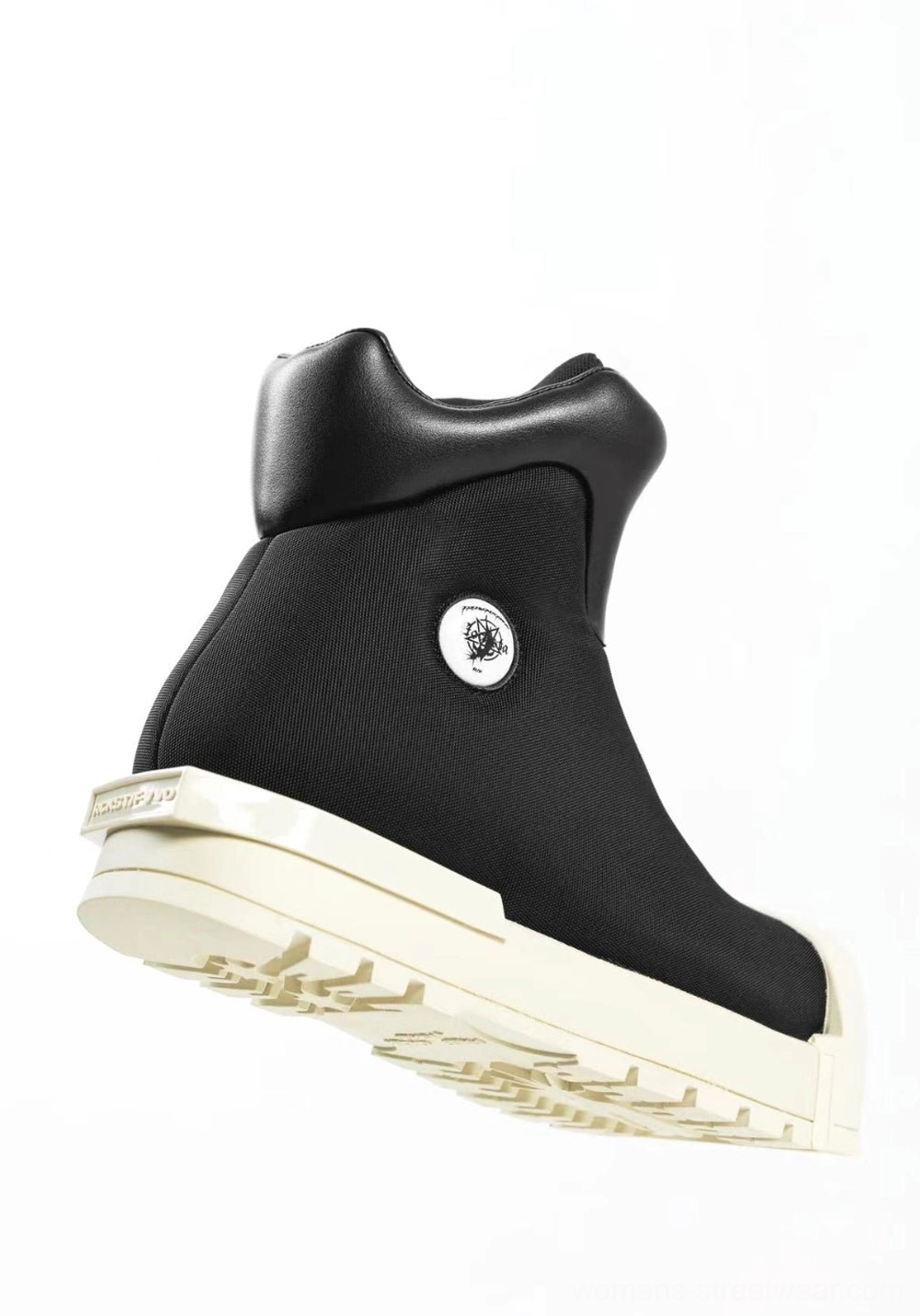 Single black sculpted-toe platform boot shown from a low rear-side angle with thick treaded outsole, padded high collar, and structured streetwear profile