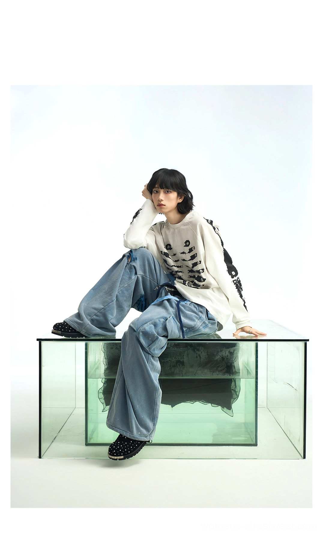 Off-white skeleton print raglan streetwear long sleeve t-shirt styled with wide-leg denim jeans in a relaxed seated outfit