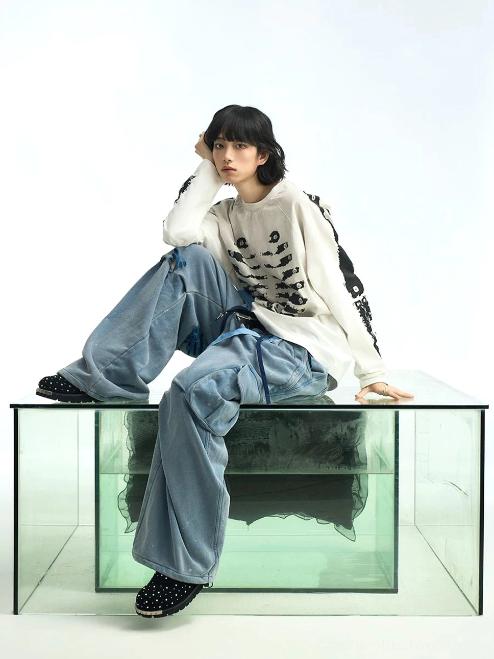 Off-white skeleton print raglan long sleeve streetwear t-shirt with a relaxed fit shown in a full-body seated studio view