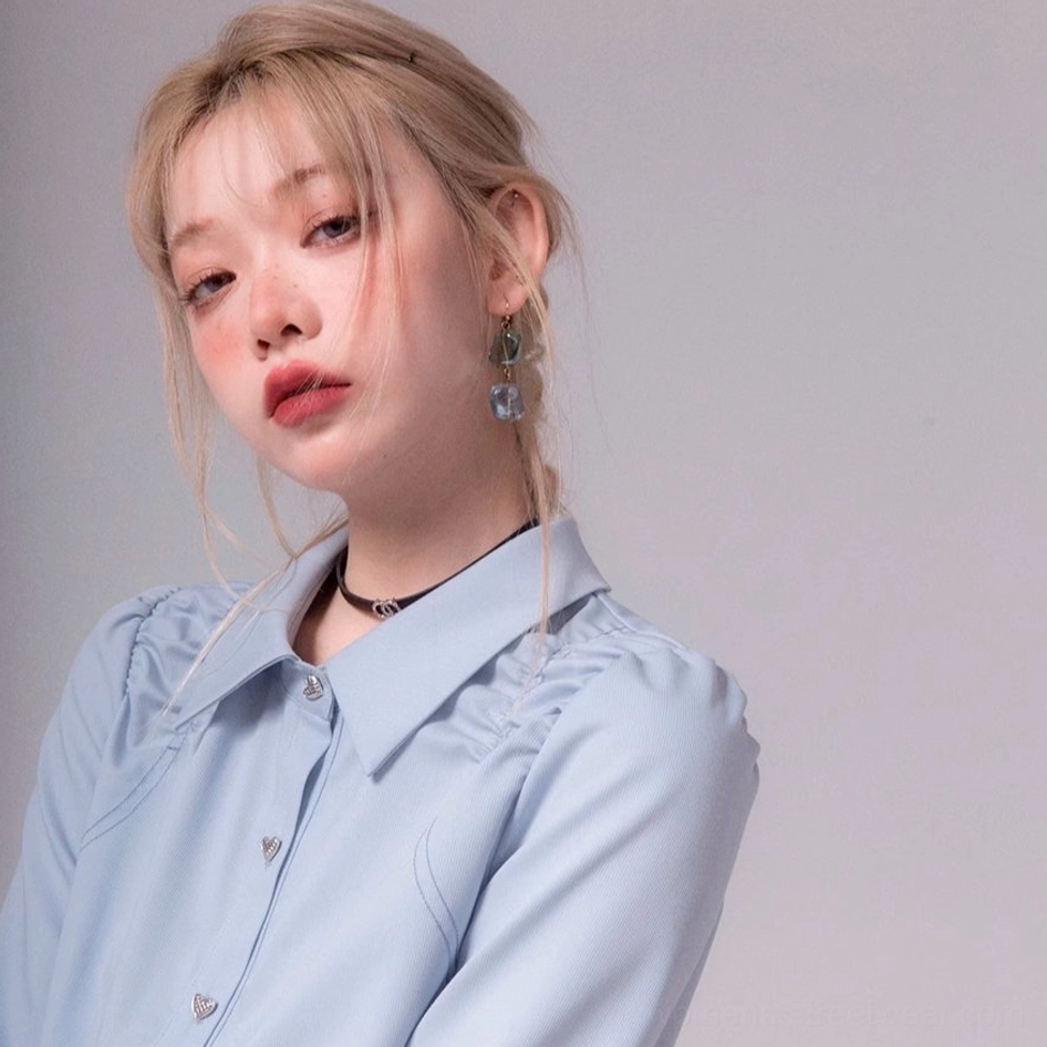 Front close-up of sky blue heart button blouse with pointed collar ruched shoulders and smooth fabric
