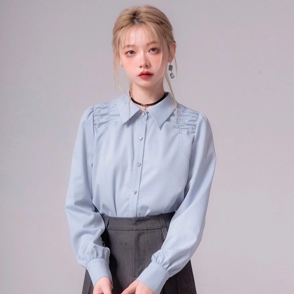 Full front view of sky blue ruched shoulder blouse with heart buttons and dark gray high-waisted skirt