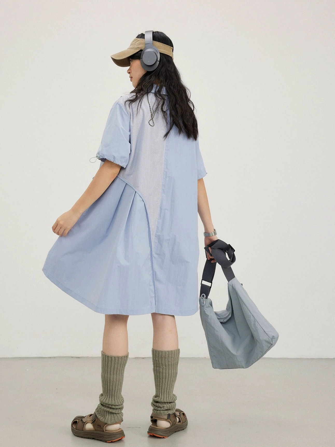 Sky blue oversized A-line shirt dress shown from the back with a gray tote bag and ribbed knee socks
