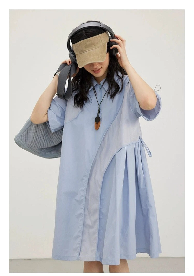 Close-up of sky blue oversized shirt dress with asymmetric panel stitching, relaxed fit, and utility streetwear details