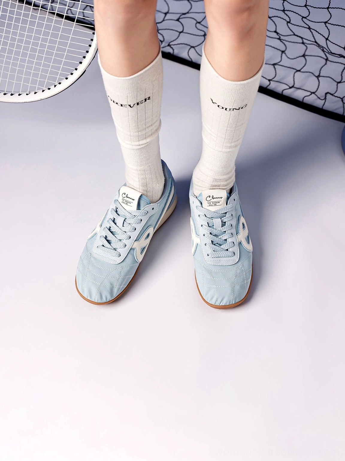 Front view of sky blue quilted gum sole retro streetwear sneakers worn with white crew socks