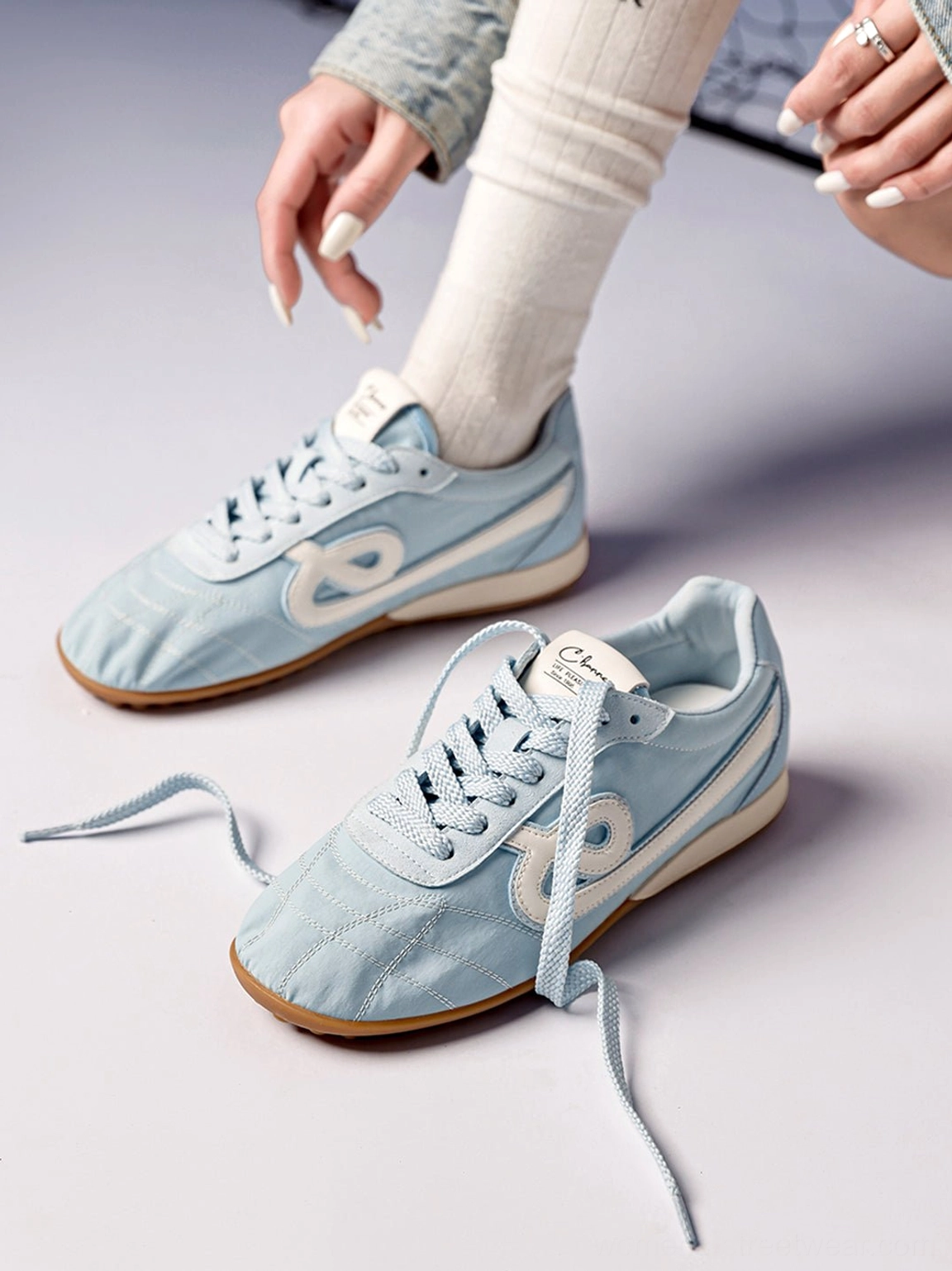 Top angled view of sky blue quilted gum sole retro streetwear sneakers with lace-up closure