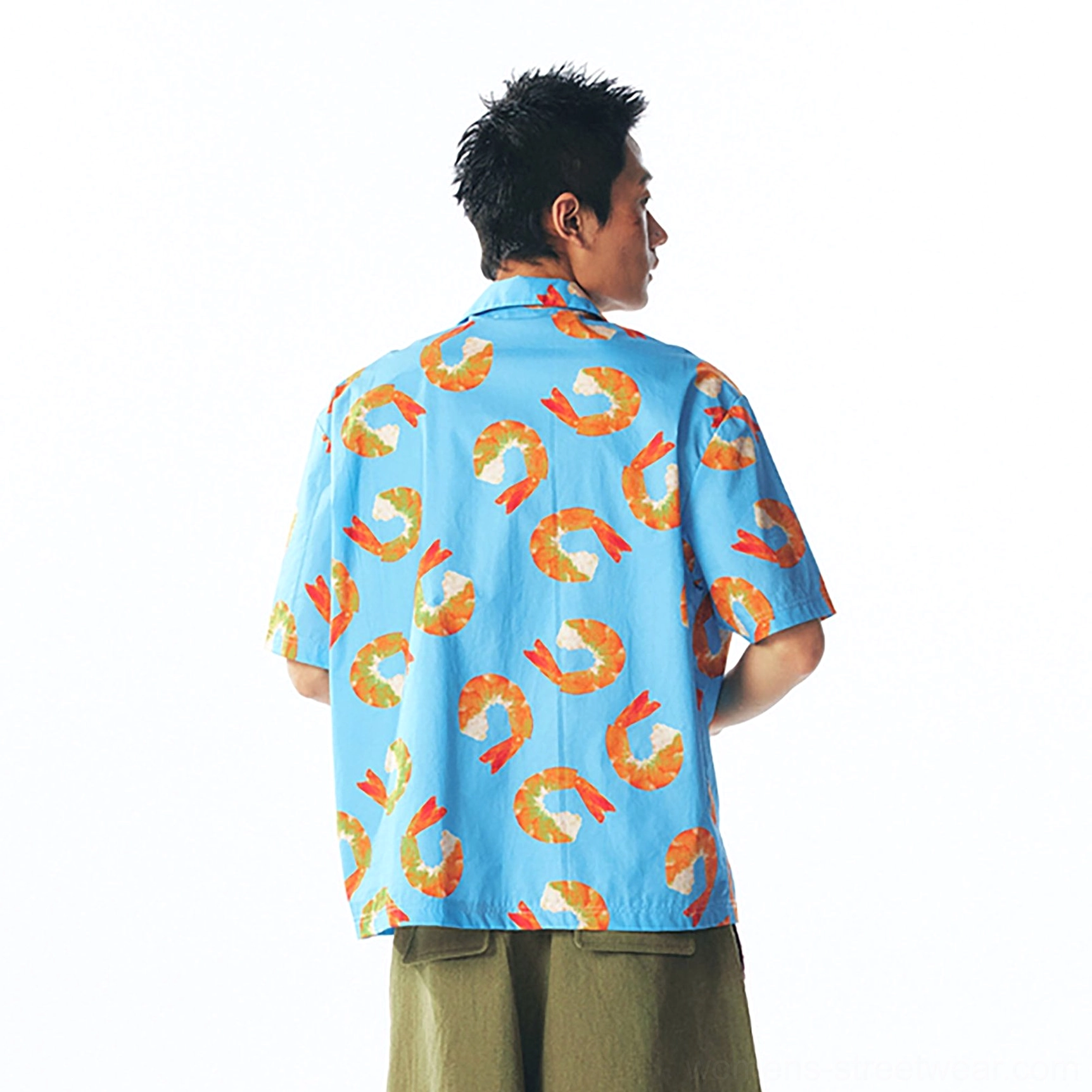 Back view of relaxed shrimp print short-sleeve button shirt with full graphic coverage styled with olive tailored trousers