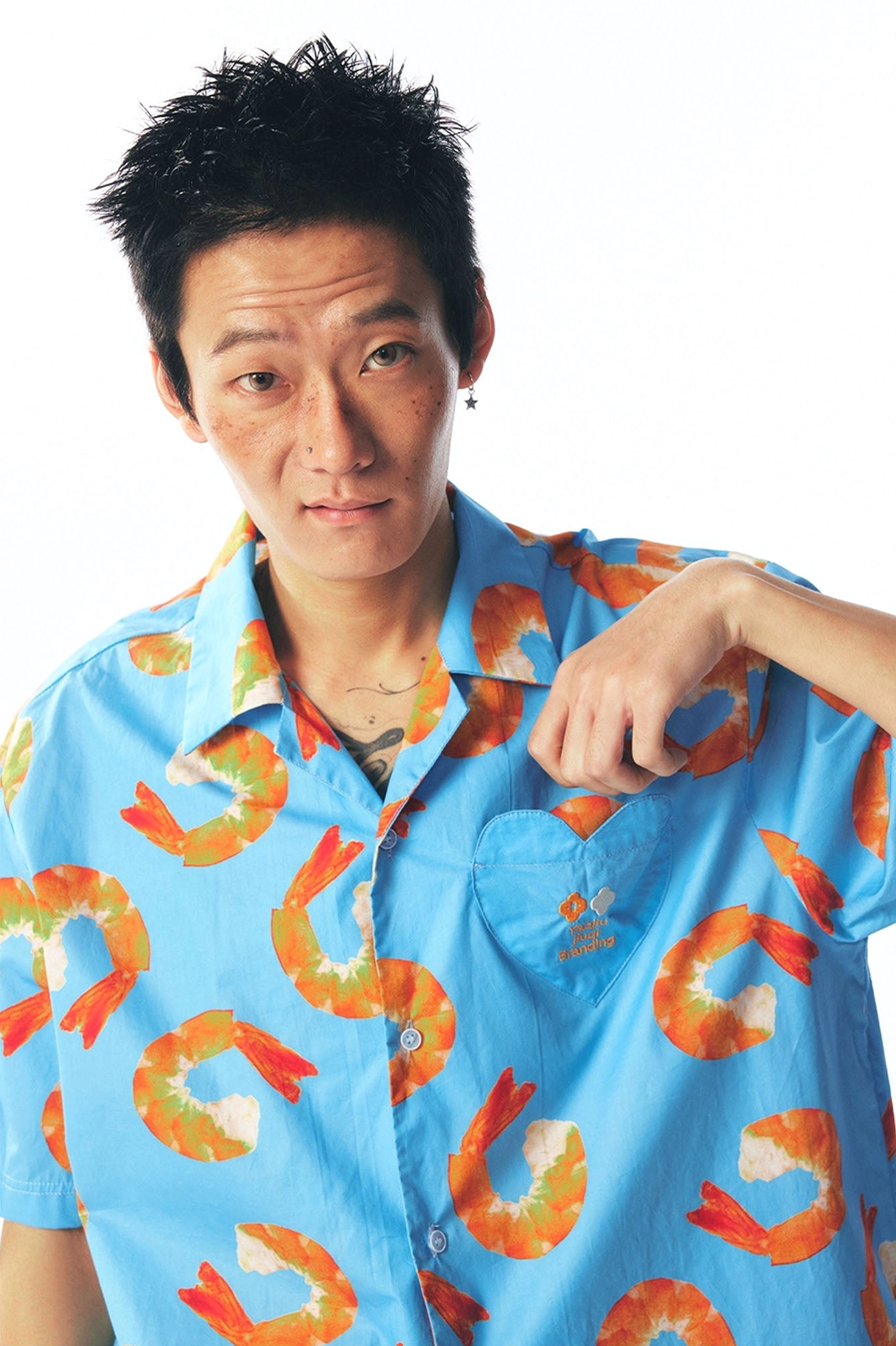 Close-up view of sky blue shrimp print shirt showing front buttons, left chest pocket, vivid graphics, and cotton texture