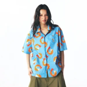 Front full-body view of sky blue shrimp print short-sleeve streetwear button shirt styled with olive wide-leg cropped pants