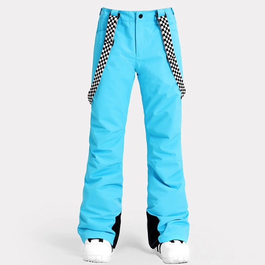 Sky blue women's snow pants with checkerboard straps, relaxed flared legs, contrasting black ankle details, and a retro ski streetwear look