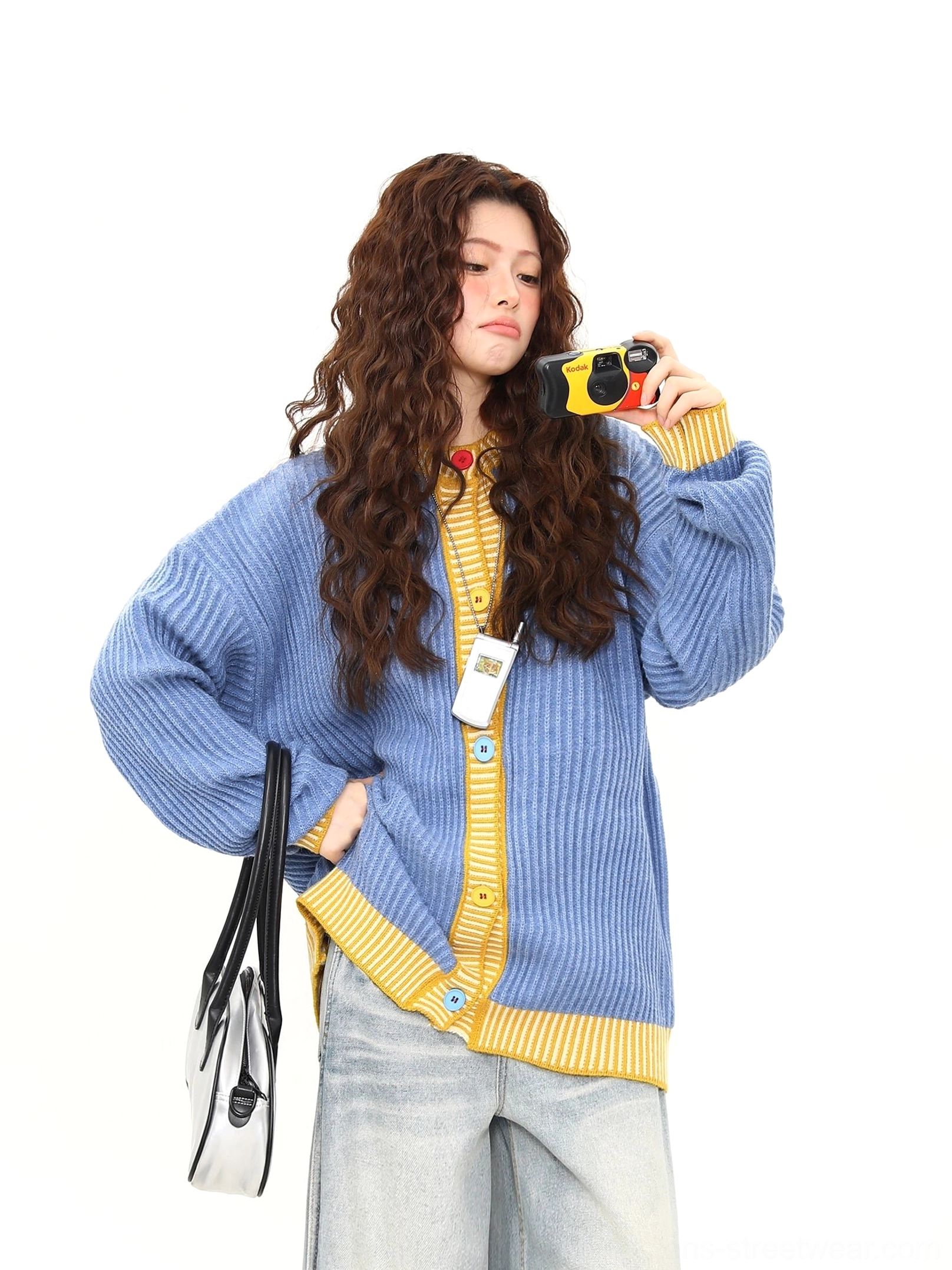 Sky blue and yellow contrast ribbed knit cardigan styled with light wash wide leg jeans in a three quarter front view