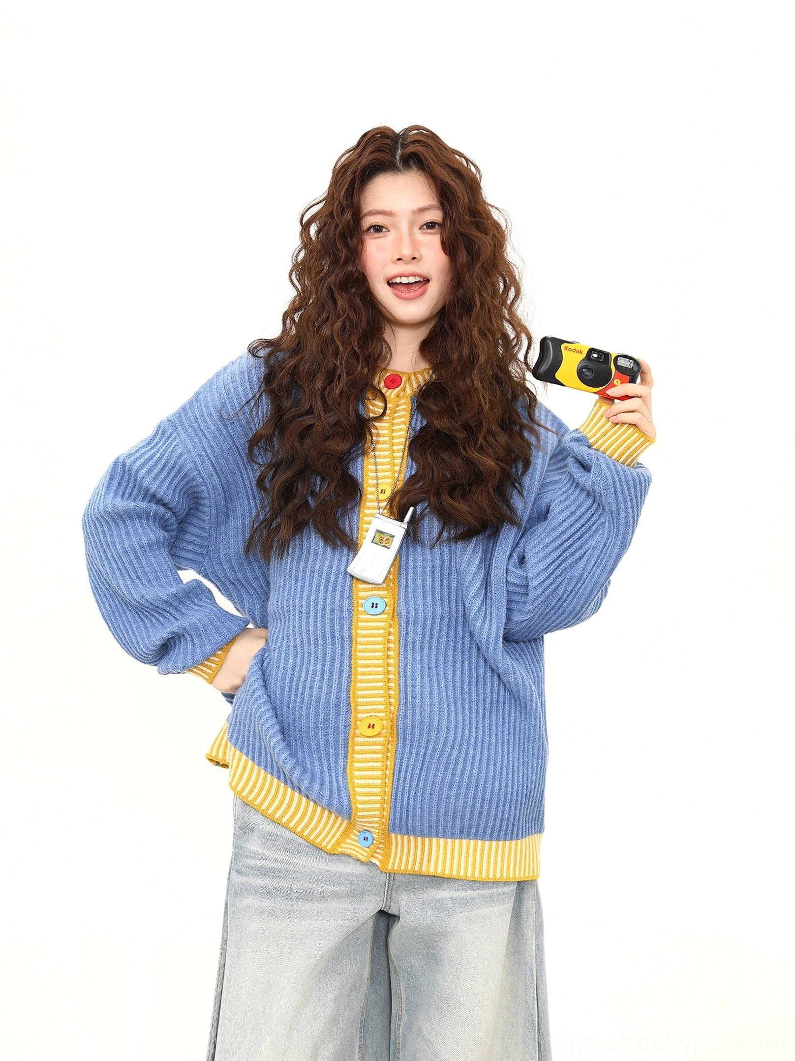 Sky blue and yellow oversized ribbed cardigan paired with wide leg jeans and a vintage camera for Seoul street style