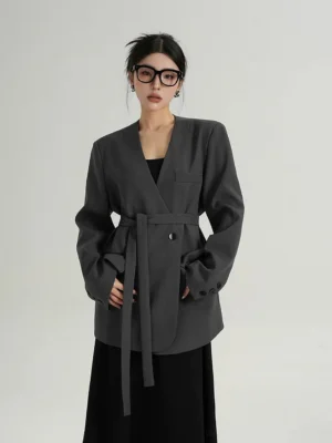 Slate gray belted blazer with collarless V-neckline, matching waist belt, padded shoulders, and relaxed Korean streetwear tailoring