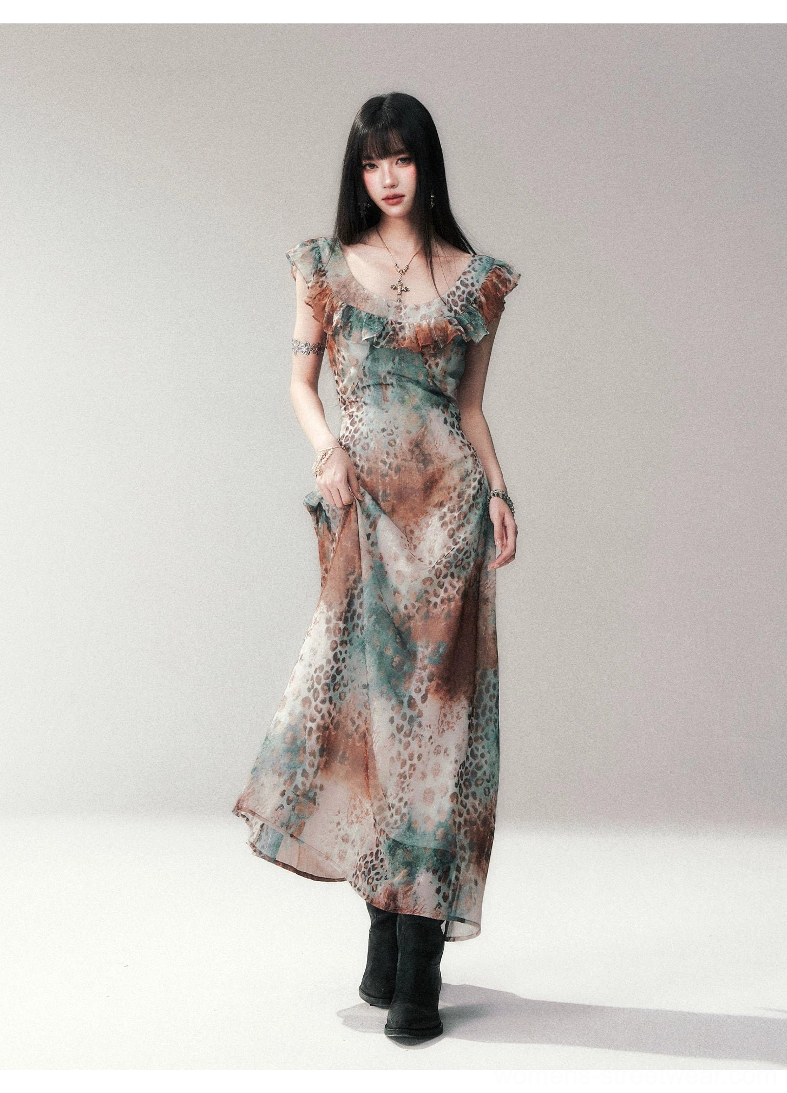 Full front view of a sleeveless watercolor leopard print ruffle maxi dress styled with black ankle boots and a fitted waist