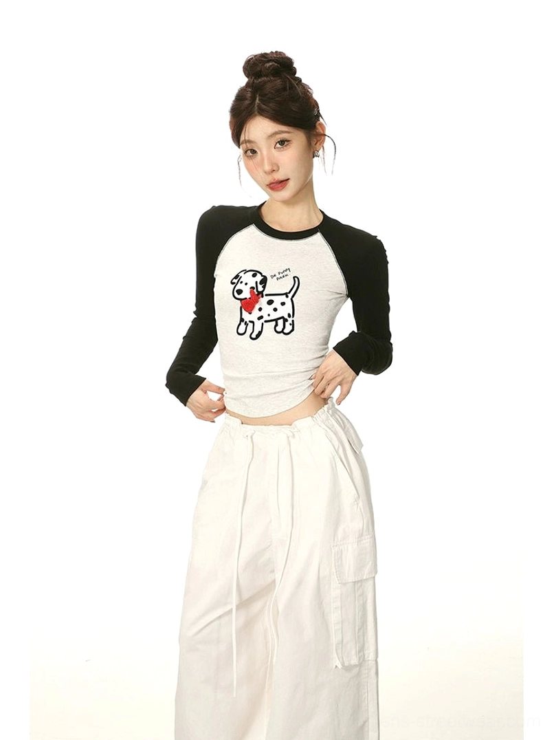 Three-quarter front view of a slim cropped Dalmatian graphic T-shirt with black long raglan sleeves and exposed waist styling
