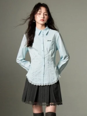 Soft sky blue fitted button-up shirt with pointed collar, chest embroidery, long sleeves, and romantic lace hem