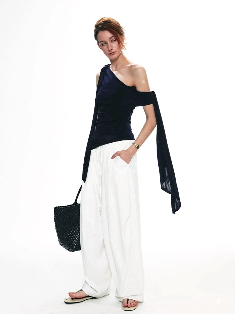 Side full-body view of a slim-fit navy velvet one-shoulder streetwear top with asymmetric hem and trailing drape