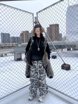Front view of oversized smoke camouflage streetwear pants with drawstring waist and stacked wide legs styled on a rooftop city backdrop