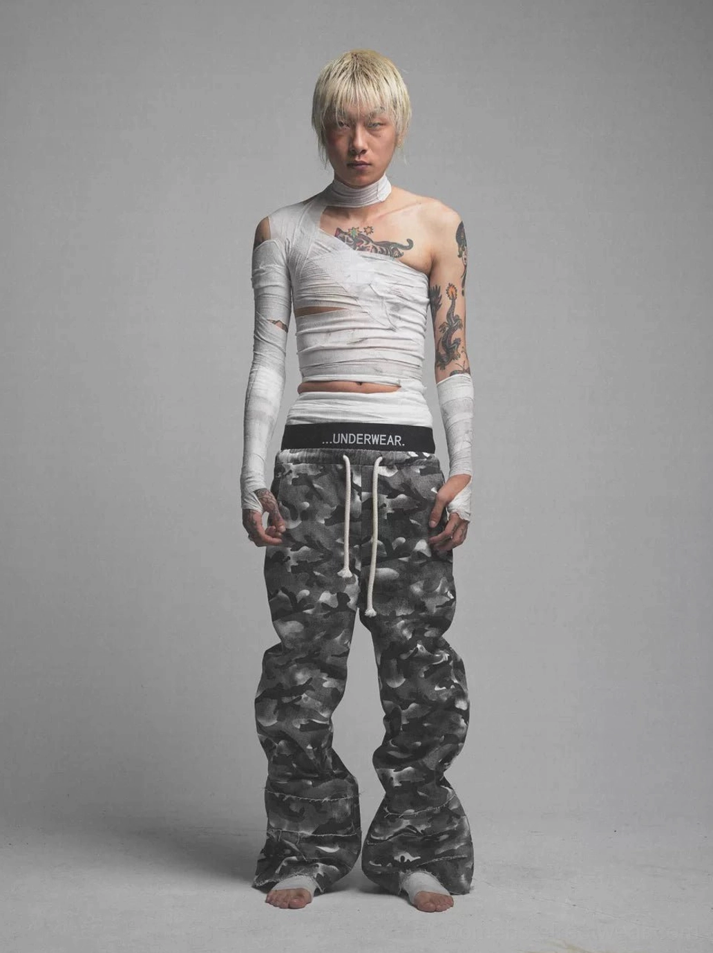 Front studio view of smoke camouflage streetwear pants with UNDERWEAR layered waistband, drawstring closure, and extra-wide legs