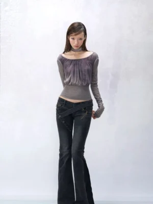 Smoky amethyst ruched halter knit top worn with dark flared jeans, featuring grey purple gradient fabric, cold shoulders, long puff sleeves, and cropped ribbed waist