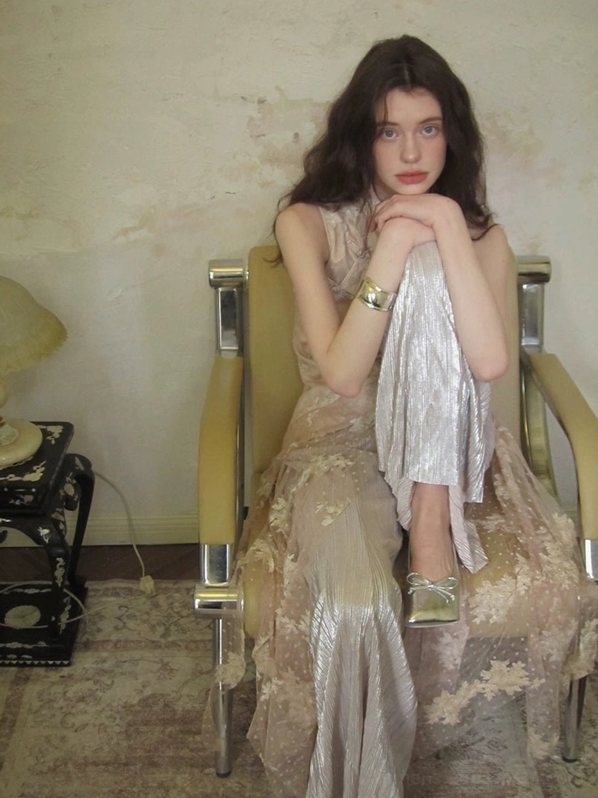 Close fashion view of delicate floral embroidery, sheer mesh layering, and flowing wide-leg details on a soft blush East Asian inspired jumpsuit