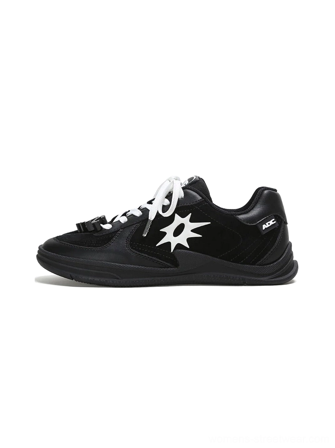 Black leather court sneaker with white solar star applique, white flat laces, and slim rubber outsole in a studio view