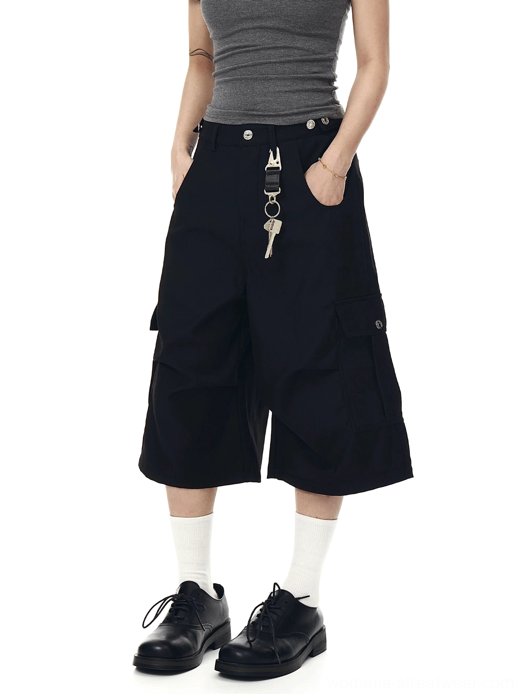 Front view of solid black oversized cargo culotte shorts with a relaxed fit, wide cropped legs, and decorative utility keychain