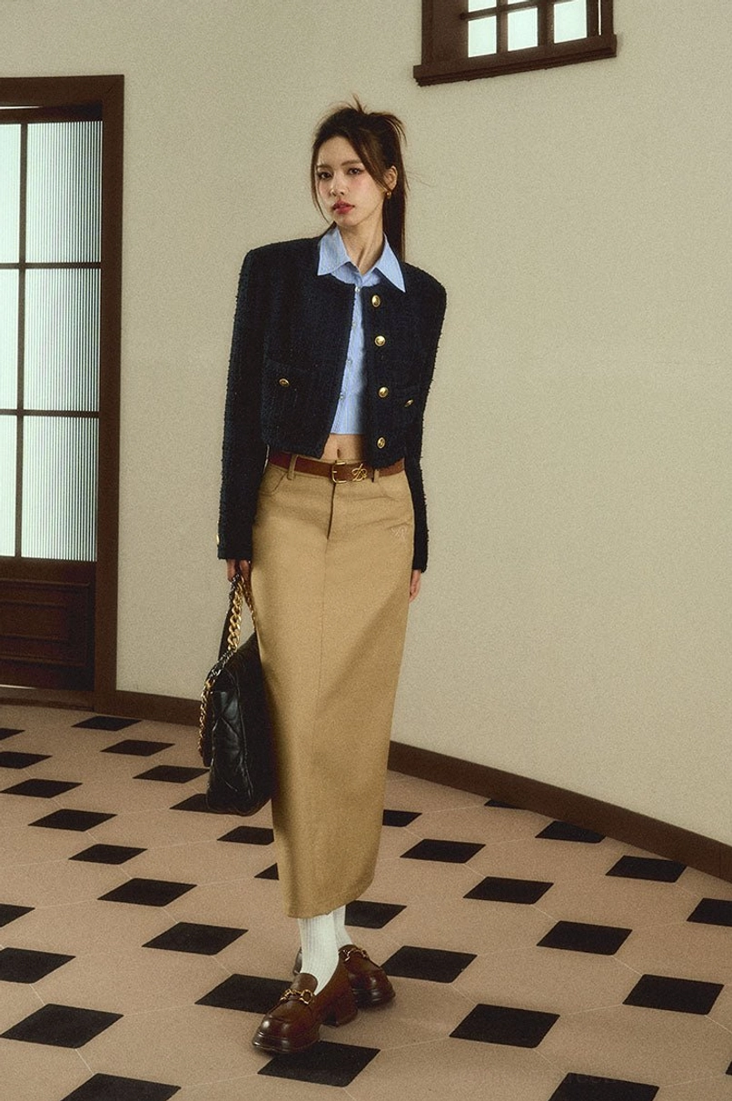 Woman modeling a solid khaki straight maxi skirt with a chain quilted shoulder bag in a vintage interior