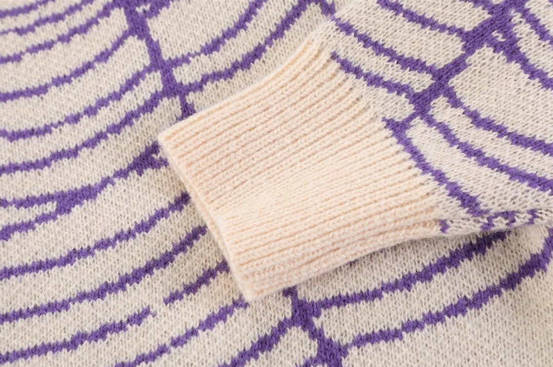 Purple cream spider web knit sweater cuff close-up showing ribbed trim and jacquard texture