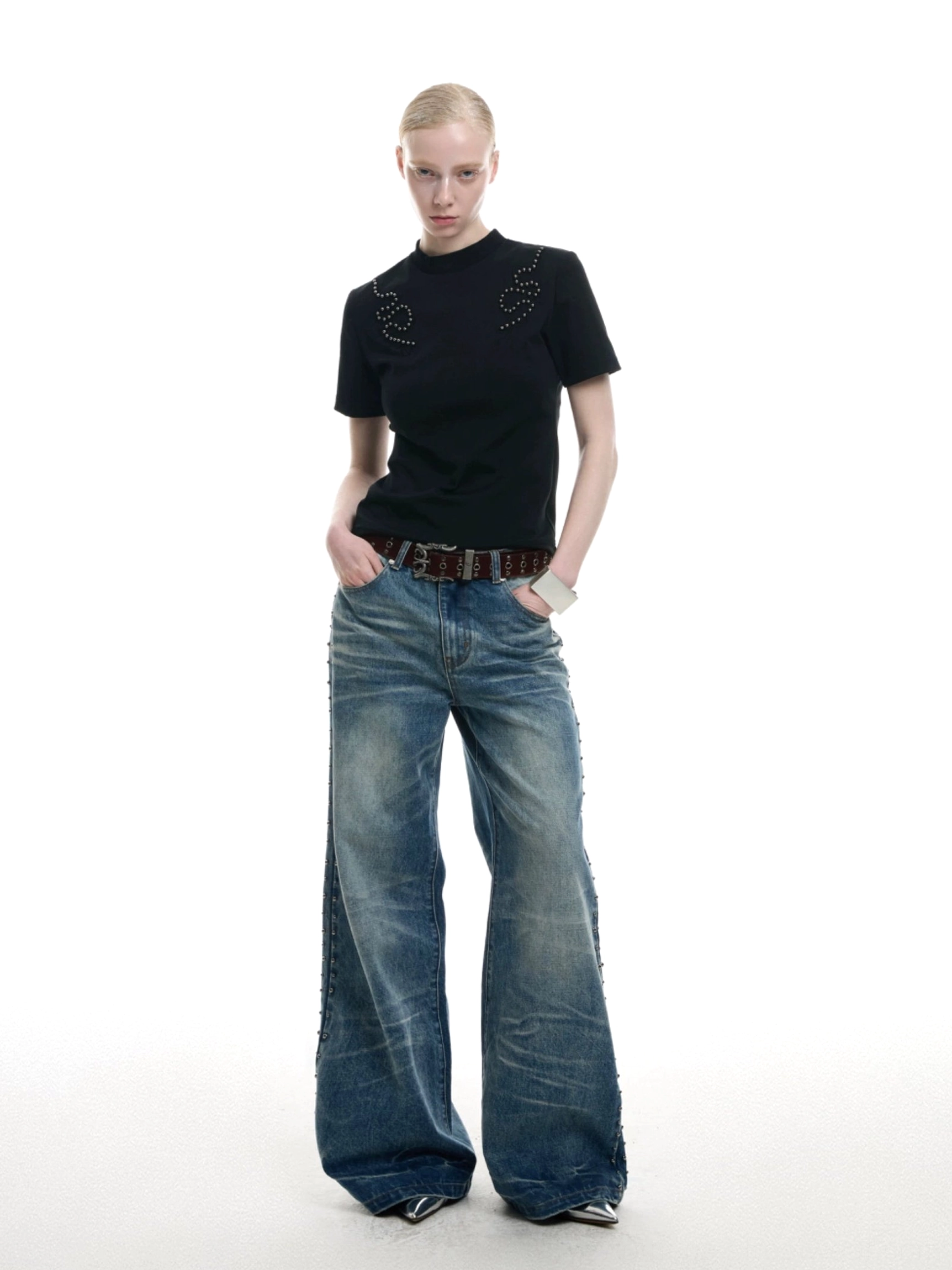 Black fitted studded crew neck T-shirt styled with wide-leg jeans and featuring swirling chest embellishments