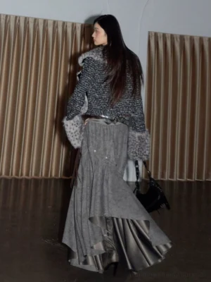 Back view of a spotted faux fur cropped jacket with dark textured tweed sleeves and bold streetwear styling
