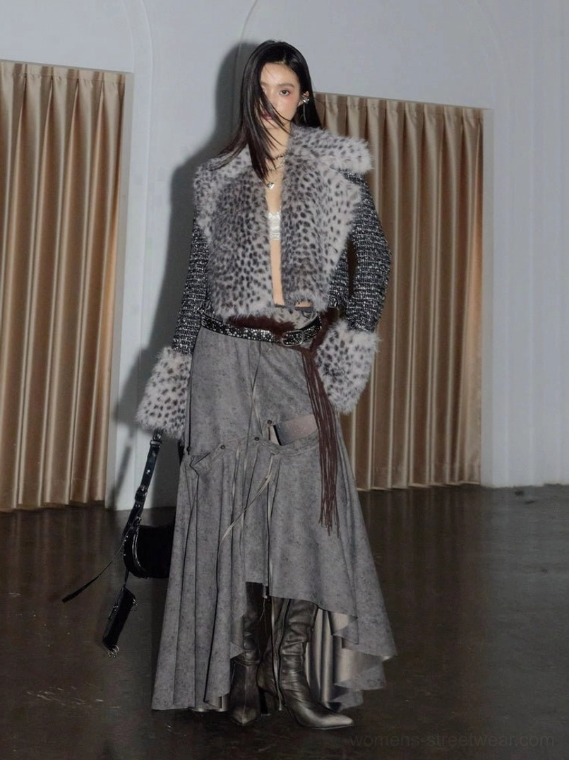 Front view of a grey spotted faux fur cropped tweed jacket styled with a maxi skirt, leather boots, waist belt, and black shoulder bag