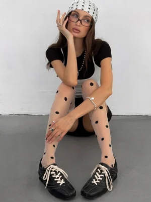 Woman styling square-toe black leather trainers with polka dot thigh-high stockings cropped black top and Seoul streetwear accessories