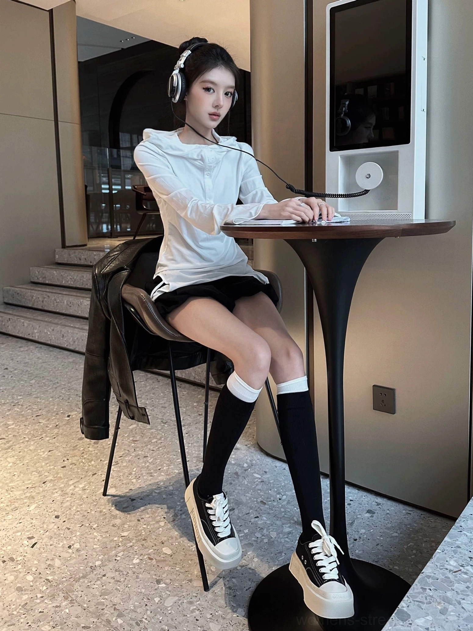 Black and off-white square toe platform canvas sneakers styled with black knee-high socks in an indoor cafe streetwear outfit