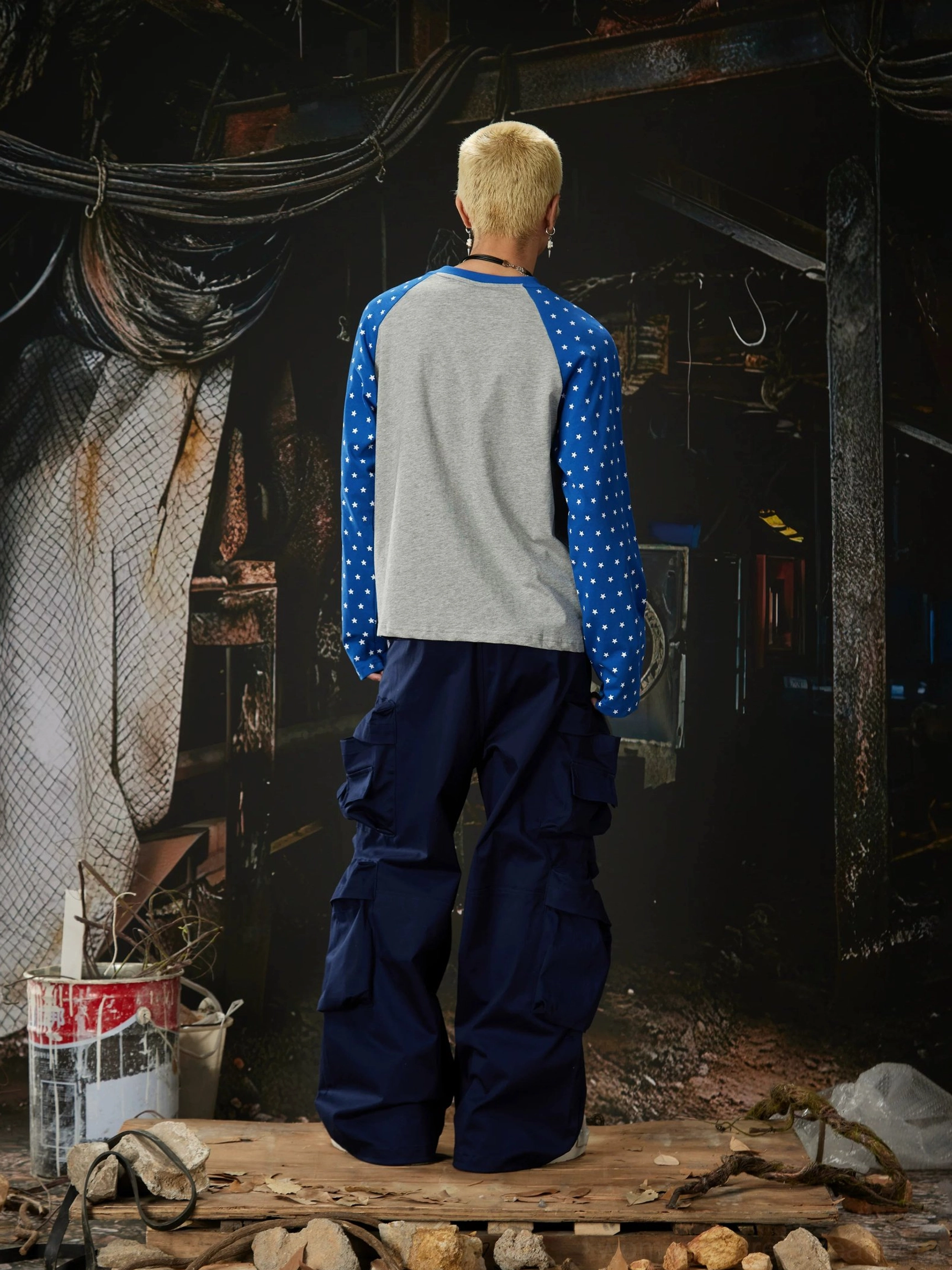 Stacked pocket streetwear cargo pants detail view highlighting loose straight-leg silhouette and functional pocket panels