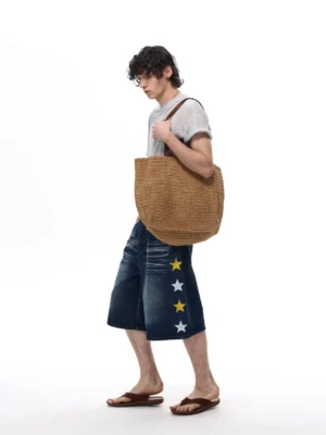 Side profile of dark washed star appliqué wide-leg denim knee shorts with relaxed oversized fit